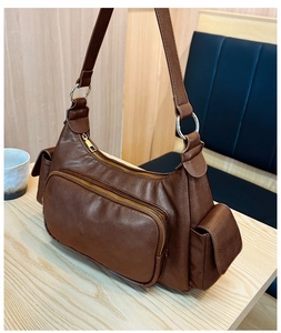 Macro detail of dark brown leather texture and dual zipper compartments on the retro bag