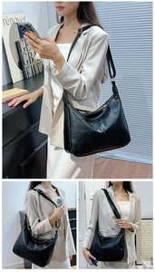 Détail de la bandoulière réglable et boucle en métal doré d'un sac hobo noir