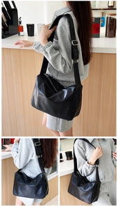 Detail view of large black PU tote bag showing soft texture and wide shoulder strap