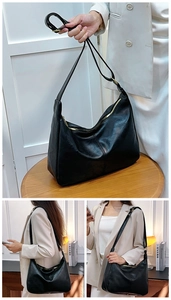 Détail d'un sac Hobo en cuir grainé noir avec fermeture éclair dorée et bandoulière