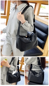 Close-up of black minimalist tote bag showing textured PU leather and silver zipper detail