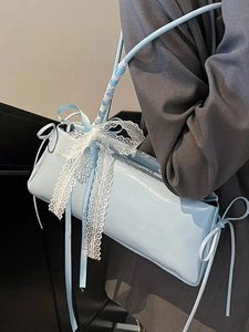 Light blue patent leather baguette bag with white lace bow and silk ribbon straps