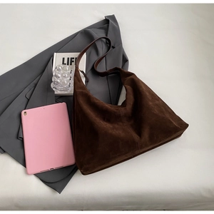 Vue détaillée du grand sac cabas en daim marron foncé avec bandoulière et drapé souple