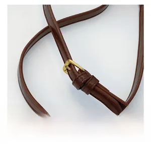 Detail of brown leather shoulder strap with adjustable gold buckle for shoulder bag