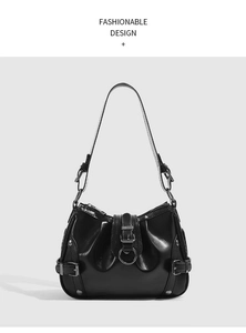 Detailed close-up of glossy black leather bag featuring pleated texture and metal buckle