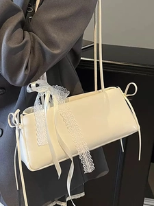 White minimalist patent leather baguette bag featuring lace trims and bow decorations