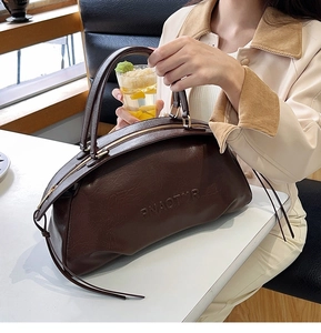 Détail du sac Boston marron foncé avec texture embossée rétro et doubles poignées