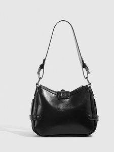 Detail of black leather underarm bag featuring silver rings and adjustable strap