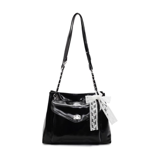 Glossy black patent leather tote bag with silver buckle and white lace bow accessory