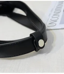 Detail of round black leather handle with silver metal buckle on a retro motorcycle bag