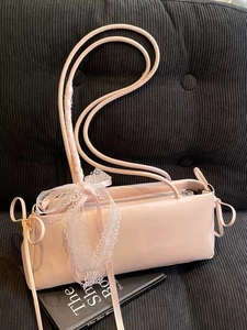 Pink patent leather baguette bag with white lace bows and drawstring coquette style