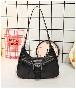 Détail du sac croissant noir vintage avec boucles argentées et double fermeture éclair