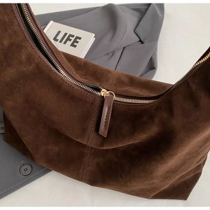 Gros plan sur la fermeture dorée et la texture daim mat d'un sac cabas vintage