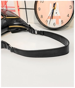 Détail de la bandoulière en cuir PU noir brillant avec anneau argenté et zips dorés
