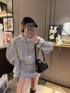 Close-up of grey hooded zip-up sweatshirt and matching drawstring skirt set for women