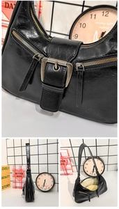 Détails du sac hobo en cuir verni noir avec fermetures éclair et boucle métallique