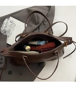Intérieur du sac en cuir marron montrant l'espace pour parapluie et cosmétiques
