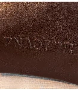 Vue macro du cuir grainé marron foncé avec logo PNAOTOR gaufré et détail de cœur