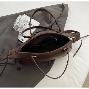 Détail du sac bowling rétro marron foncé montrant la poche intérieure et le grain de cuir