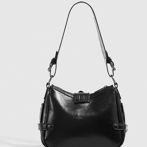 Glossy black underarm motorcycle bag with vintage buckle and adjustable straps