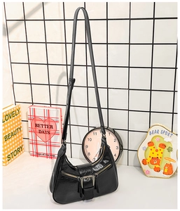 Détail d'un sac hobo noir en demi-lune avec boucles argentées et doubles zips décoratifs