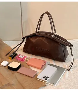 Sac Boston en cuir marron foncé montrant sa grande capacité pour tablette et objets