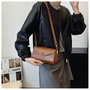 Brown vintage leather crossbody bag featuring a classic envelope flap and round snap button