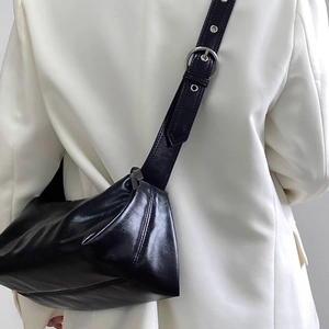 Minimalist black glossy leather crossbody bag with wide shoulder strap and silver buckle