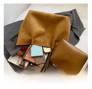 Detail showing internal capacity of brown suede tote bag with tablet and notebook