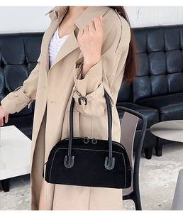 Detail of black Boston bag with white contrast stitching and dual long handles