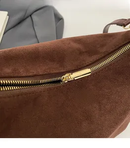 Close-up of smooth gold metal zipper and premium brown suede texture on vintage handbag