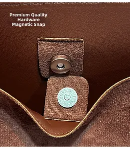 Detail of premium silver magnetic clasp on brown leather bucket bag with suede interior
