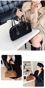 Detail of matte leather boston bag with white contrast stitching and double zipper closure