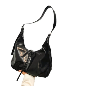Minimalist black crescent leather tote bag with adjustable strap and silver hardware