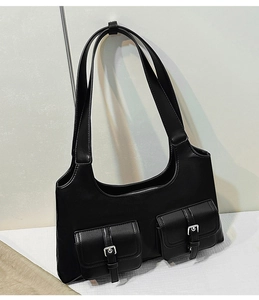 Detail of vintage black shoulder bag featuring dual pockets and silver metal buckles