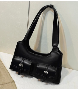 Detail of vintage black hobo bag showing two front utility pockets and silver metal buckles