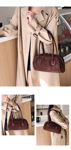 Detail of dark brown suede shoulder bag featuring elegant white contrast stitching and zippers