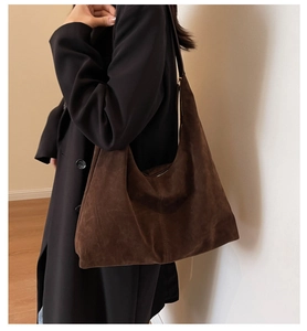 Détail de la texture du sac hobo en daim marron foncé et design minimaliste de la bandoulière