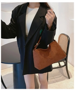 Close-up of brown matte suede shoulder bag featuring a vintage minimalist trapezoid design