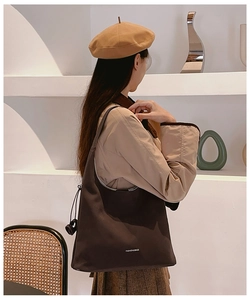 Dettaglio della coulisse e della scritta sulla borsa tote marrone in nylon da donna