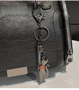 Dettaglio borsa Boston in pelle martellata nera con zip argento e ciondolo a gatto