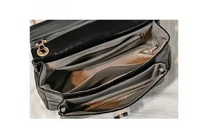 Interior view of black quilted flap bag showing multi-compartment lining and pockets