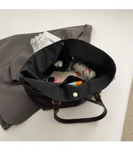 Top view of the black tote bag interior showing large capacity and multiple pockets