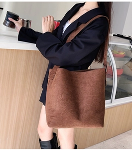 Detail shot of a brown frosted suede tote bag with wide shoulder strap and metal buckle