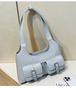 Detail of light blue leather bag featuring double pockets and metallic buckle closure