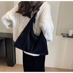 Vue détaillée du grand sac cabas en daim noir porté par un mannequin au style minimaliste