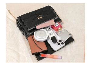 Detail view of black quilted crossbody bag showing spacious interior with daily essentials