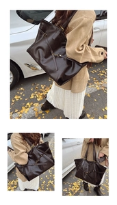 Detail view of coffee brown tote bag with metal buckle and autumn street background