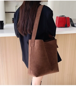 Detail view of large brown faux suede tote bag with wide strap and matte texture