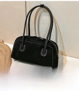Detail view of black faux suede shoulder bag with white decorative stitching and zip closure